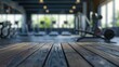 © bagoesanggito - Wooden table in a modern fitness center with blurred gym equipment in the background