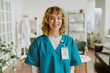 © AnnaStills - Portrait of blonde nurse looking at camera directly and smiling widely showing her teeth