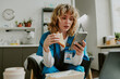 © AnnaStills - Good looking Caucasian nurse biting fresh sandwich while chatting on social media