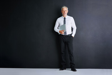 Canvas Print - Mature business man, laptop and studio with mockup space for smile, pride or portrait by black background. Person, executive or actuary with computer for risk assessment at insurance agency in London