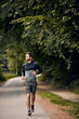 © Daniel L�/peopleimages.com - Morning, fitness and man in park for running challenge, wellness and healthy outdoor exercise. Training, cardio and runner on path in nature with commitment, progress and athlete in muscle workout.