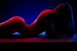 © Michael Rekochinsky - Beautiful young brunette woman lying in sexy lingerie in colored light in studio on a dark background