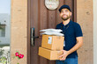 © AntonioDiaz - Portrait of a delivery person bringing online shopping orders in boxes and envelopes to a house