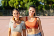 © Xavier Lorenzo - Portrait of two young athletic women smiling at camera after workout routine outdoor