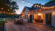© Abdul - Suburban farmhouse with a large wooden deck and outdoor dining area under string lights