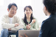 © kapinon - 営業マンの説明を受ける笑顔の50代夫婦　投資や保険、不動産など　笑顔でクローズアップ