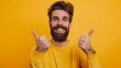 © Berkah - Young handsome man with beard over isolated yellow background with thumbs up because something good has happened.
