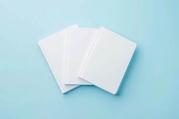 Poster - flatlay of three white notebooks, on a pale blue background, product mockup 