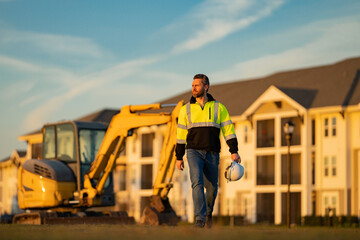 Wall Mural - Builder on excavator. Builder worker with excavator. Builder in helmet. Worker in hardhat. Portrait mechanical worker in construction helmet. Engineer builder foreman or repairman.