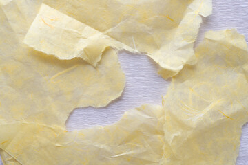 Wall Mural - torn yellow tissue paper pieces arranged randomly on white crepe paper sheet