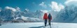 © tongpatong - A backdrop of peaks and two hikers in the mountains traversing through snow