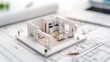 © PrusarooYakk - 3D model of a modern home layout displayed on architectural blueprints, showing interior design and space planning for residential property development.