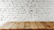 © tashechka - Rustic wooden table in front of a white brick wall, creating a simple yet charming backdrop for various uses.