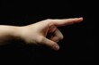 © Ольга Лукьяненко - A hand pointing to the left Isolated on black background