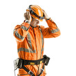 © AlexCaelus - Construction worker in orange safety uniform putting on helmet and earmuffs, isolated on white background.