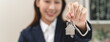 © Pormezz - Close up view realtor broker holding home keychain in her hand and showing to new owner.