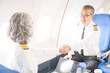 © NanSan - Mature male and female pilots meet inside an airplane, holding hands. Their gesture signifies teamwork, trust, and camaraderie in aviation, fostering a safe and collaborative work environment.