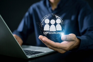 Outsourcing Global Recruitment Business and internet concept . Business person hand holding outsourcing icon on virtual screen