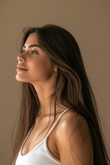 Beauty, haircare, and face of woman with curls in studio for growth shine on brown backdrop. Elegant woman with long, colored, and healthy hair who cares for herself or after salon visits.