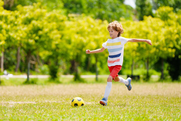 Wall Mural - Child playing football. Kids play soccer.