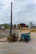 © Anastasiia - The image depicts a construction site with a pile driver and auxiliary equipment under a cloudy sky, suggesting ongoing heavy construction work, possibly for laying foundations.