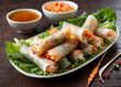 © HayashiCraft - Traditional spring rolls with vegetables and shrimp, served with a spicy dipping sauce, photographed to show the whole plate.