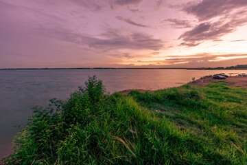 Wall Mural - The background of the sea by the evening sea, with natural beauty (sea water, rocks, sky) and fishermen are fishing by the river bank, is a pleasure during travel.