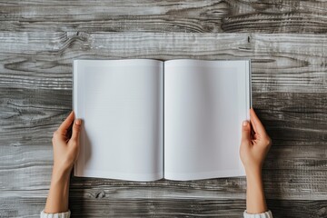 Blank pages of a book held open by two hands on a wooden background