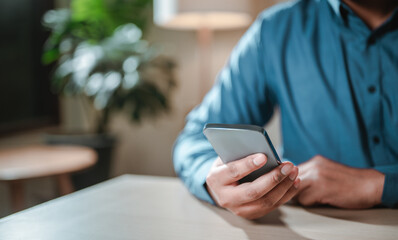 connection, wireless, technology, lifestyle, mobile phone, smartphone, marketing, touch, reading, social. A man is sitting with a cell phone. He is possibly checking his messages or playing internet.