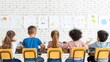 © Panuma - Five children sitting on yellow chairs at a table in front of a white brick wall, engaged in drawing and painting activities.