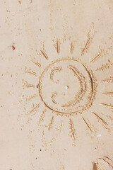 Wall Mural - Smiley face drawn in sand on beach with sun and waves in background