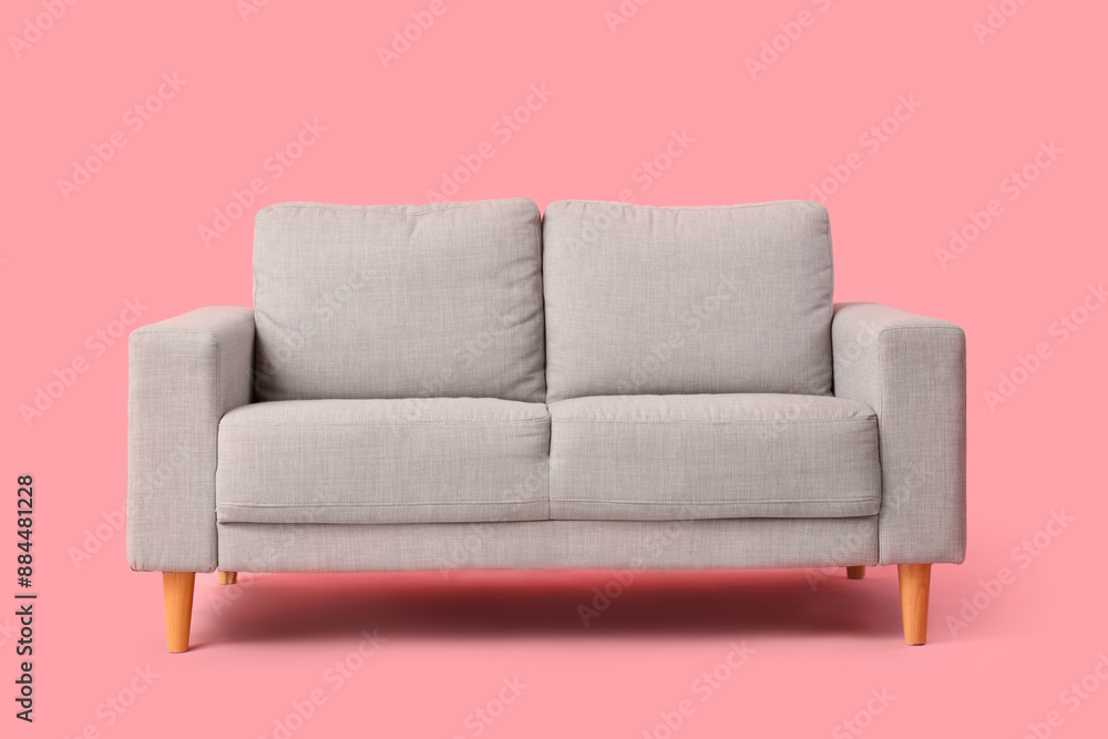 Cozy grey sofa on pink background