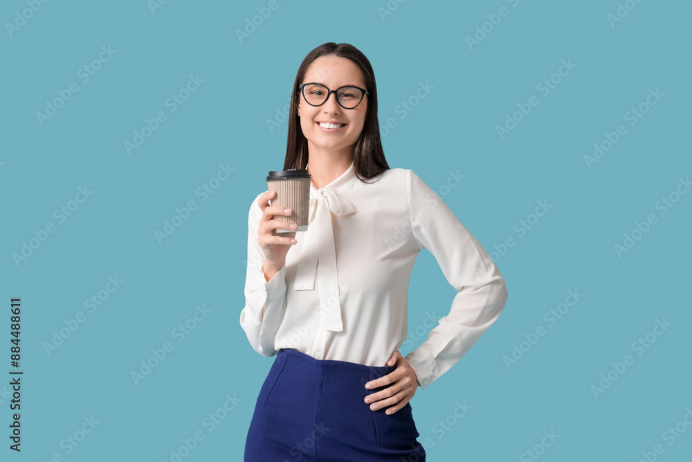 Young beautiful secretary with cup of coffee on blue background