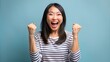 © Suchithra - Excited asian lady eager for a yes stands over a white background. Joy of Victory  Lady Shaking Fists