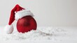 © TheWaterMeloonProjec - Red Christmas ball and Santa hat on white background