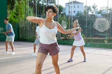 Wall Mural - Latin woman playing frontenis on outdoor pelota court during training. Woman playing Basque pelota speciality.