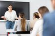© JackF - Young female tutor teaching students in college classroom