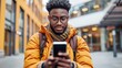 © StrawberryShortcake - Young Man in Yellow Jacket with Backpack Using Smartphone in the City, Urban Lifestyle Concept.