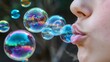 © StrawberryShortcake - Close.up, profile view child gently blowing with a wand many rainbow coloured soap bubbles