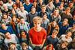 © MVProductions - Stand out from the crowd concept with blonde man standing out from large crowd of people