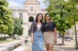 © HelloUG - Two 30-something Indian Malaysian women posing in various ways and enjoying their holiday in front of a beautiful building in a historic cobblestone park in City Centre, Kuala Lumpur, Malaysia.