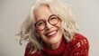 © Naknakhone - Happy positive blonde elder woman in stylish eyeglasses looking at camera with perfect toothy smile, laughing, posing for home portrait. Image of old woman.