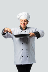 Young female chef with frying pan and spatula isolated on white- professional culinary expert