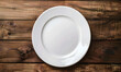 © john - Empty white plate on wooden table background. Top view with copy space