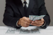 © Pheniti - Businessman hand holding banknotes. Business, money, investment , finance, corruption or payment concepts.