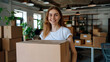 © Phichitpon - Young woman carrying large box during a move to new home or package delivery