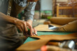 © Prathankarnpap - Cropped shot of artisan working on the workbench with different rolls brown leather