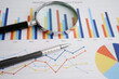 © manassanant - Magnifying glass on charts graphs paper. Financial development, Banking Account, Statistics, Investment Analytic research data economy.