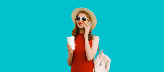 Wall Mural - Happy cheerful young woman calling on phone with cup of coffee in tourist hat with backpack