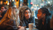 © Anna - Three friends having a conversation at a cozy cafe with warm lighting and blurred city street in the background. Gossip, friendship, coffee culture, urban lifestyle, casual meeting concept